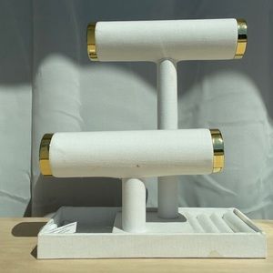 White jewelry stand with gold detailing.